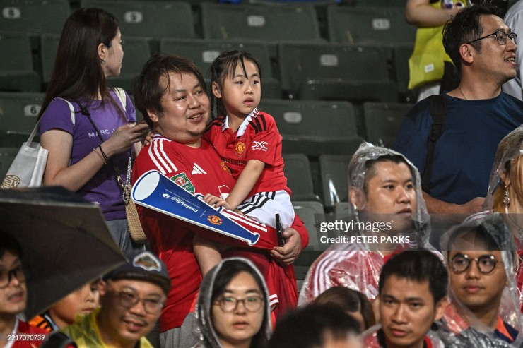 Một bé gái theo bố đi cổ vũ đội bóng yêu thích