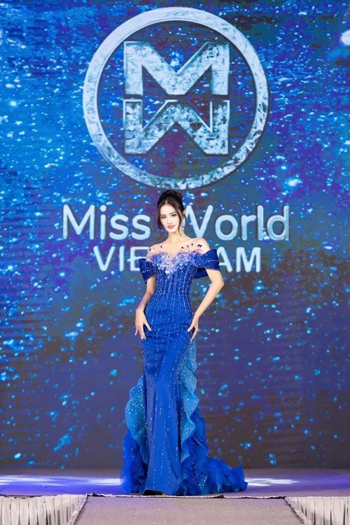 Về đầm dạ hội cho chung kết, trước khi đi thi, người đẹp công bố hai mẫu váy dạ hội dành cho chung kết. Bộ đầm màu xanh mang tên Aurora of the sea của NTK Hoàng Tony lấy cảm hứng từ hiện tượng cực quang hiếm gặp trên biển – nơi sóng nước giao hòa cùng bầu trời tạo nên những vệt sáng kỳ ảo. Thiết kế trễ vai vừa gợi cảm vừa sang trọng được đính kết tỉ mỉ. Phần tà váy được xử lý xếp tầng mềm mại, gợn sóng uyển chuyển. Ảnh: FB Ý Nhi.