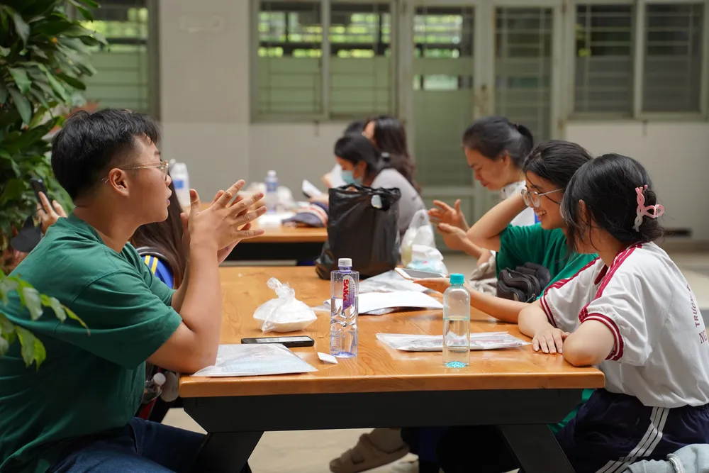 Thí sinh tranh thủ trao đổi, ôn bài thêm trước khi vào phòng thi. Ảnh: THÁI BẢO