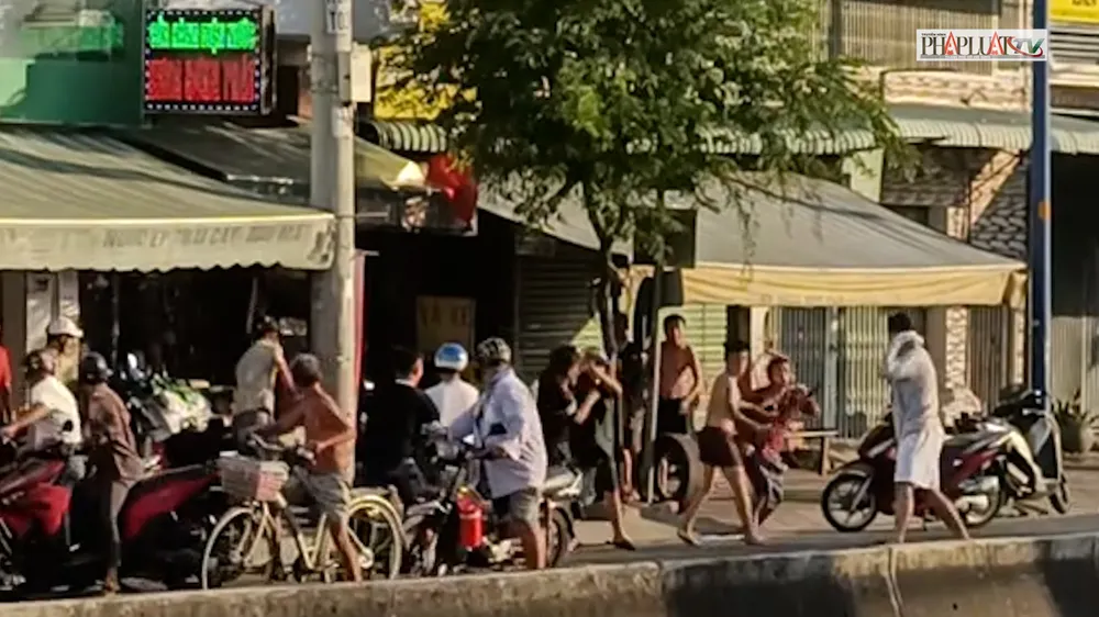 Một số người trong nhóm thể hiện thái độ hung hãn, cầm hung khí truy đuổi đối phương. Ảnh cắt từ clip