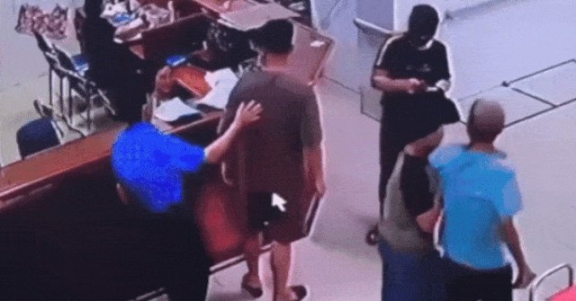 Người đàn ông chồm qua quầy làm thủ tục tấn côn...