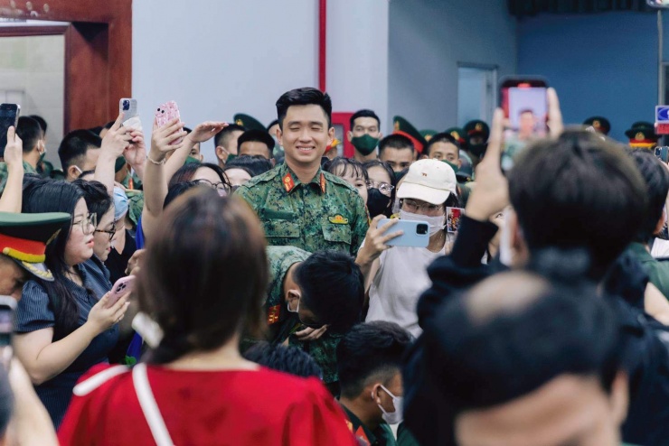 Thượng úy Hiệp gượng cười giữa đám đông người vây quanh và chụp ảnh