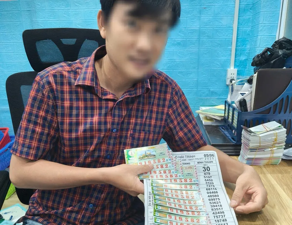 Chủ đại lý vé số đang kể về việc đã đổi thưởng cho người trúng thưởng 14 tờ vé số giải đặc biệt. Ảnh: H.T