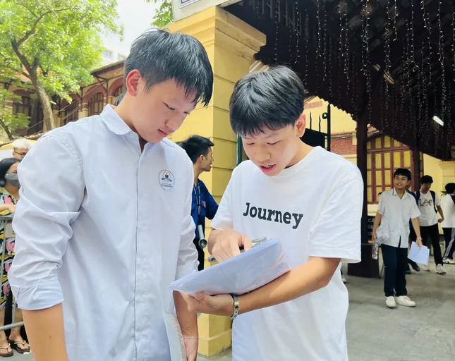 Thí sinh trao đổi bài sau khi hoàn thành bài thi môn Toán tại điểm thi THPT Trần Phú, Hoàn Kiếm (Hà Nội). ảnh: Hà Linh