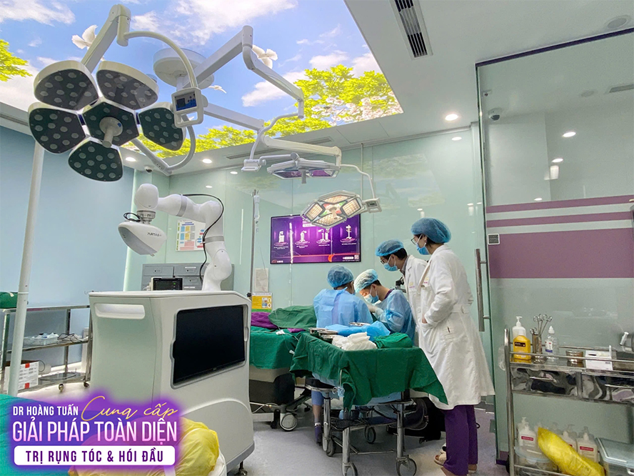 PGS.TS Nguyễn Ngọc Tuấn cùng đội ngũ bác sĩ tại Dr Hoàng Tuấn đang thực hiện cấy tóc bằng robot bán tự động NEO GRAFT.