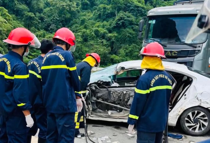 Cảnh sát cắt khung xe Kia đưa thi thể nạn nhân ra ngoài. Ảnh: Lam Sơn