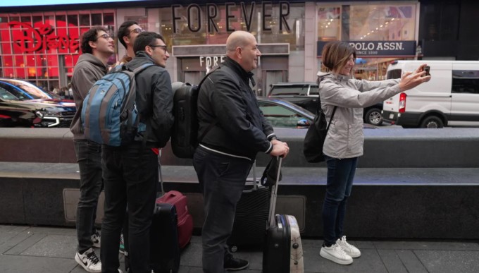 Renée Rewiski, hướng dẫn viên du lịch tại New York, đang chụp ảnh cùng một nhóm khách mà cô đang dẫn tour. Ảnh: CNN