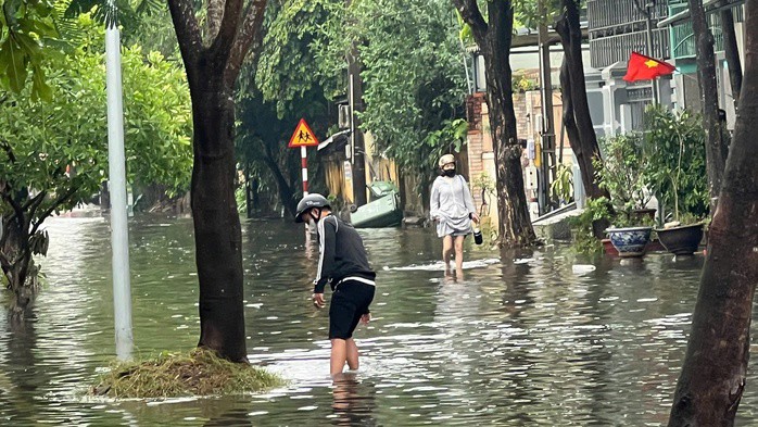 Ngập úng đường phố khiến phương tiện, con người di chuyển khó khăn.