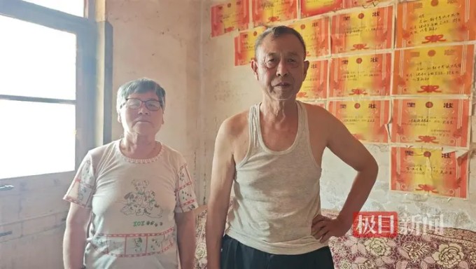 Ông bà Vương bên góc nhà dán bằng khen thành tích học tập của hai cháu. Ảnh: 163