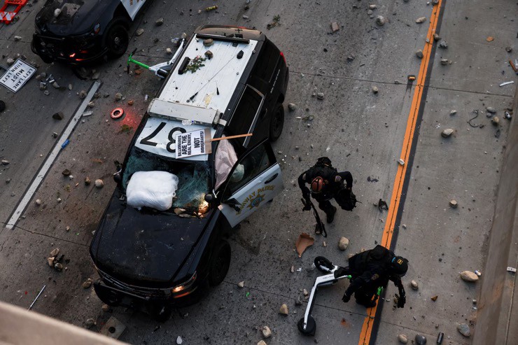 Một chiếc xe cảnh sát bị hư bại trong làn sóng bạo lực ở Los Angeles, bang California. Ảnh: Reuters.