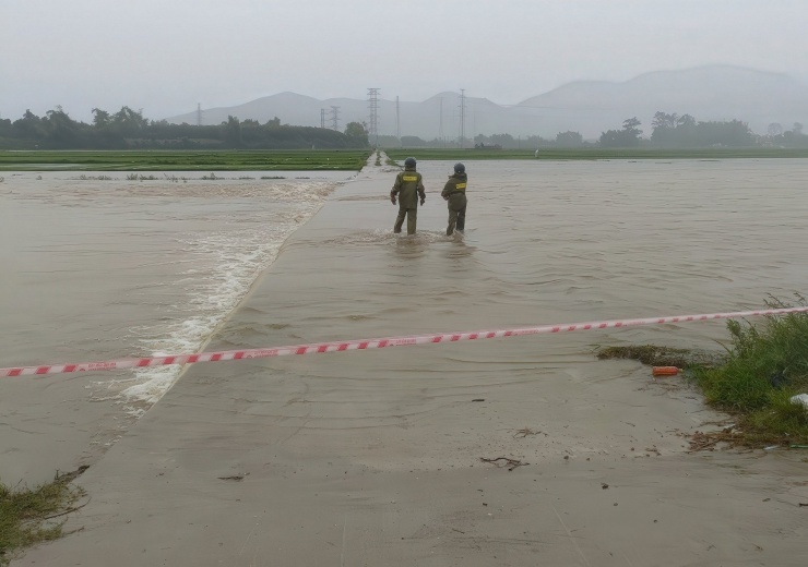 Lực lượng chức năng huyện Duy Xuyên giăng dây cảnh báo người dân không qua lại ở khu vực nguy hiểm. Ảnh: Công Bình