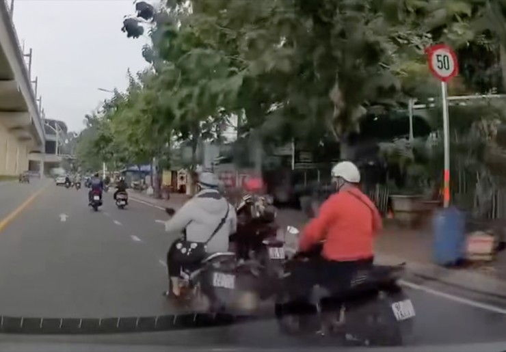 Thanh niên áo cam vung chân đạp lần đầu nhưng... hụt. Ảnh: Cắt từ clip