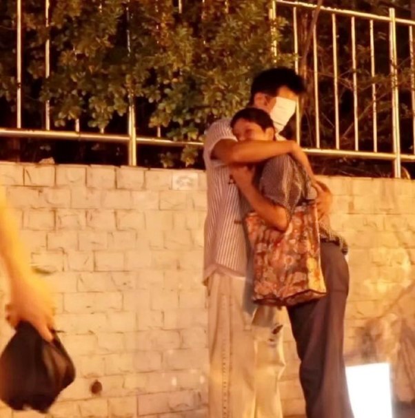 Hình ảnh Nhậm Tuyền đeo khẩu trang kín mặt, trao những cái ôm ấm áp tới người đi đường vào năm 2023.