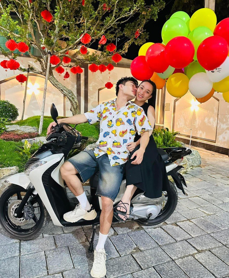 Hai vợ chồng đứng trong sân vườn.