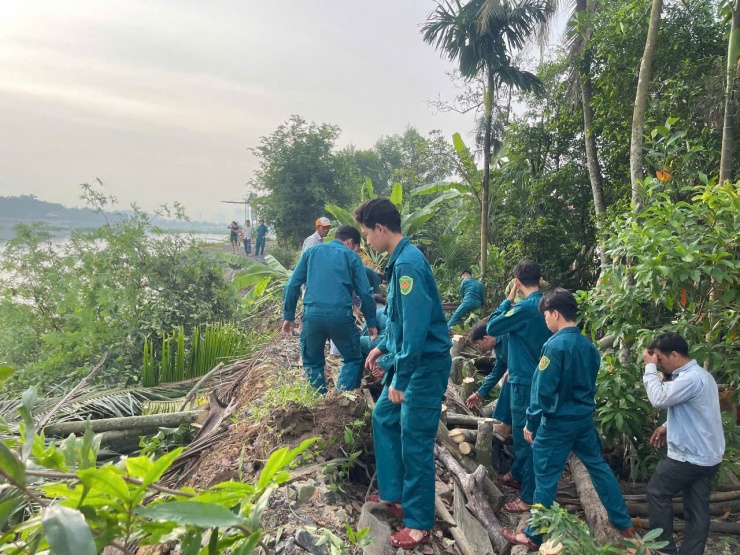 Lực lượng dân quân tự vệ hỗ trợ di dời các hộ dân bị ảnh hưởng và tiến hành gia cố đoạn bờ bao ven sông Sài Gòn bị sạt lở. Ảnh: M. Hoàng.