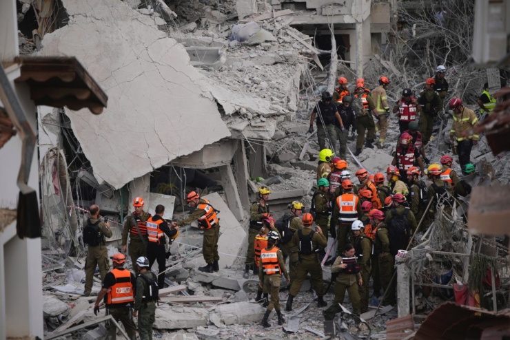 An ninh Israel kiểm tra những ngôi nhà bị phá hủy.