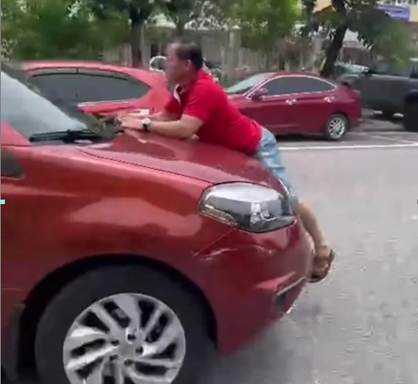 Người đàn ông bám nắp capo ngăn tài xế ô tô bỏ chạy sau tai nạn. Ảnh cắt từ video clip.