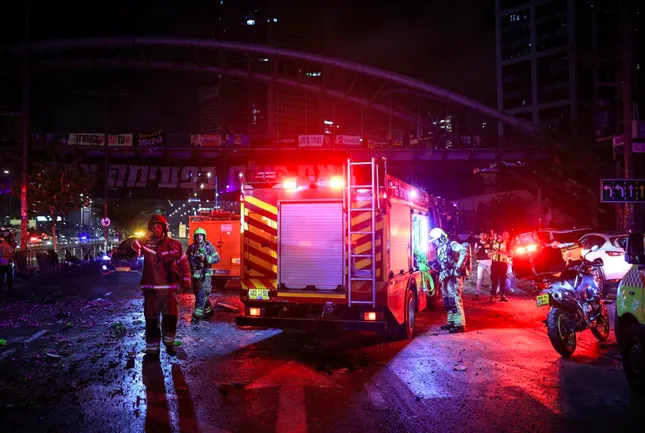 Đội cứu hoả làm nhiệm vụ ở Tel Aviv sau khi Iran phóng hàng trăm tên lửa tấn công đáp trả. (Ảnh: Reuters)