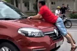 Công an làm việc với tài xế và người đàn ông bám vào capo ô tô chạy giữa phố