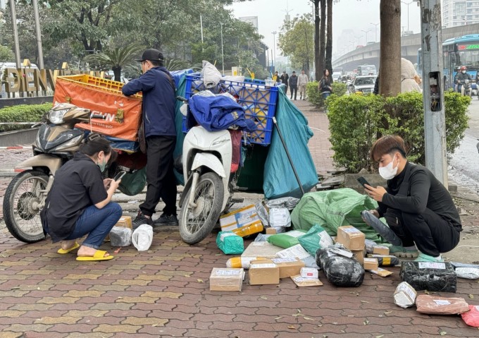 Shipper chờ khách nhận hàng tại phố Duy Tân, Cầu Giấy, Hà Nội, tháng 2/2024. Ảnh: Ngọc Thành