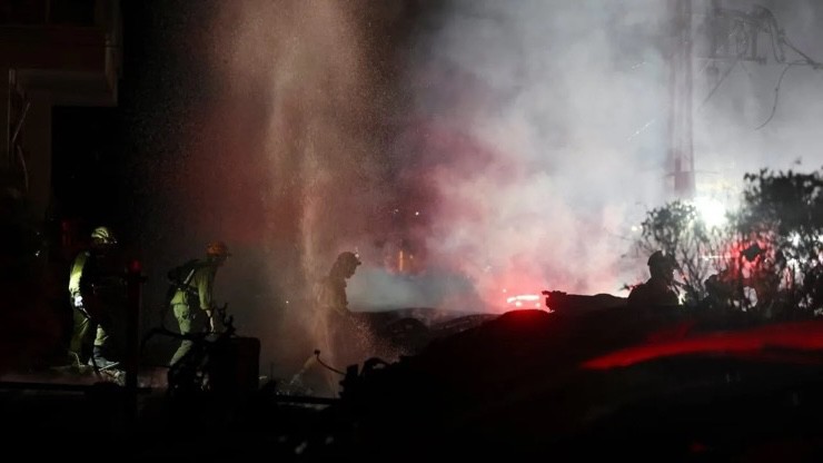 Nhân viên cứu hộ Israel có mặt tại hiện trường sau cuộc tấn công tên lửa của Iran ở thành phố Haifa. Ảnh: Reuters.