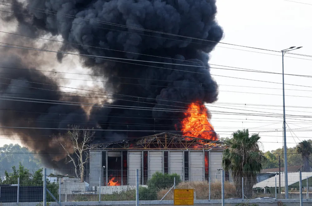 Một tòa nhà ở TP Herzliya (Israel) bốc cháy sau cuộc tấn công của Iran vào rạng sáng 17-6. Ảnh: AFP