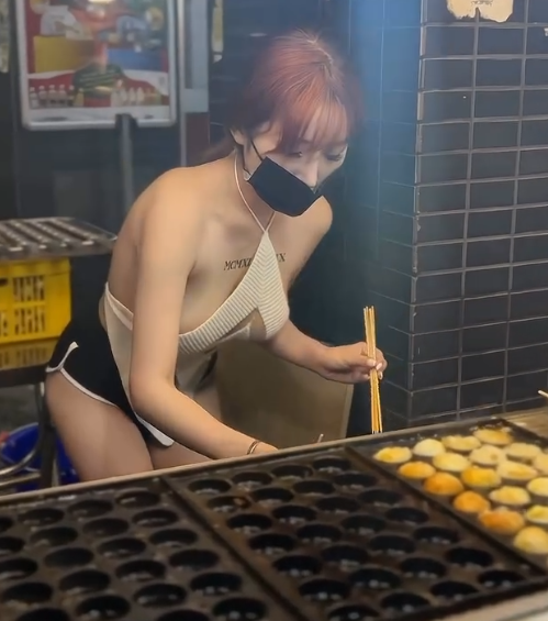 Hình ảnh cô gái trẻ, ngoài 20 tuổi, đứng bán hàng giữa chợ đêm với bộ trang phục "mát mẻ" nhanh chóng lan truyền trên mạng xã hội.