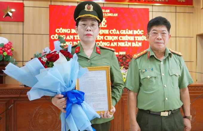 Đại tá Nguyễn Văn Hòa, Phó giám đốc Công an Long An (phải) trao quyết định tuyển dụng cho chị Nguyễn Thị Thúy Diễn. Ảnh: Công an Long An