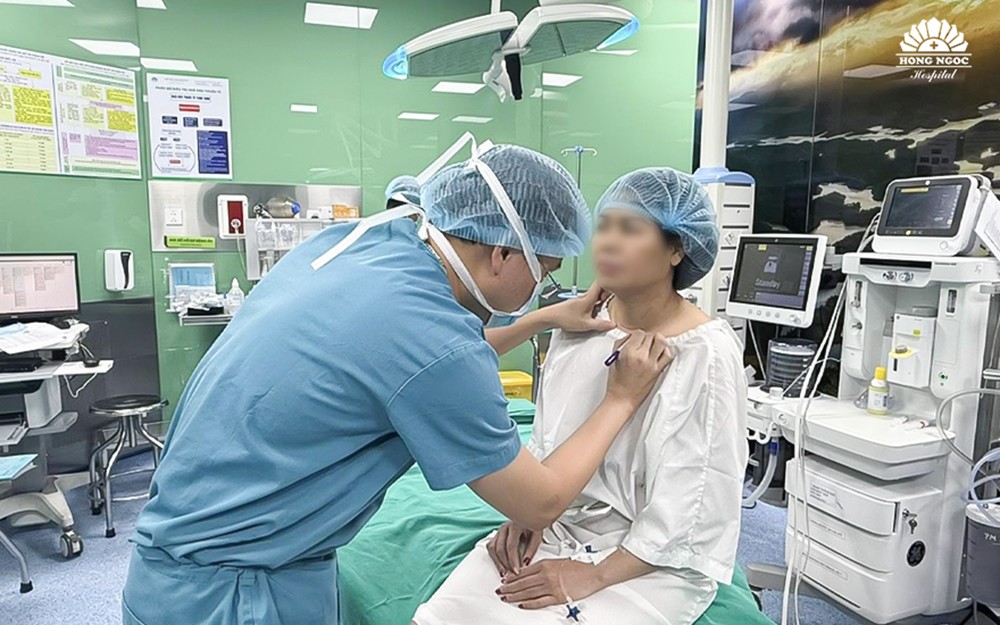 Phẫu thuật viên thực hiện chọn và đánh dấu vị trí rạch da trên cổ bệnh nhân