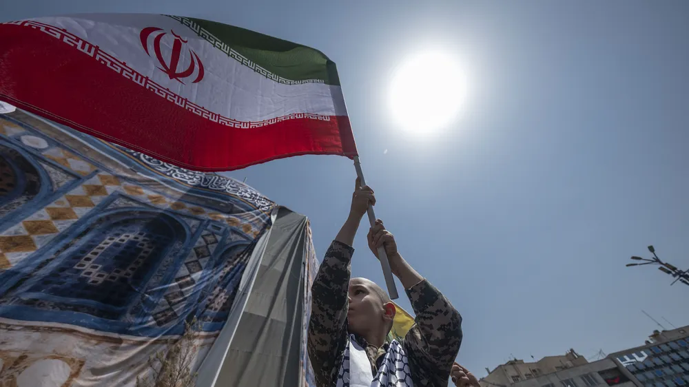 Một cậu bé Iran vẫy cờ phản đối các cuộc không kích của Israel, tại Tehran (Iran) ngày 20-6. Ảnh: VCG