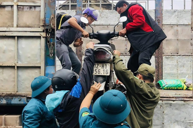 Lực lượng chức năng hỗ trợ người dân di chuyển qua các điểm ngập. Ảnh: Đức Sơn