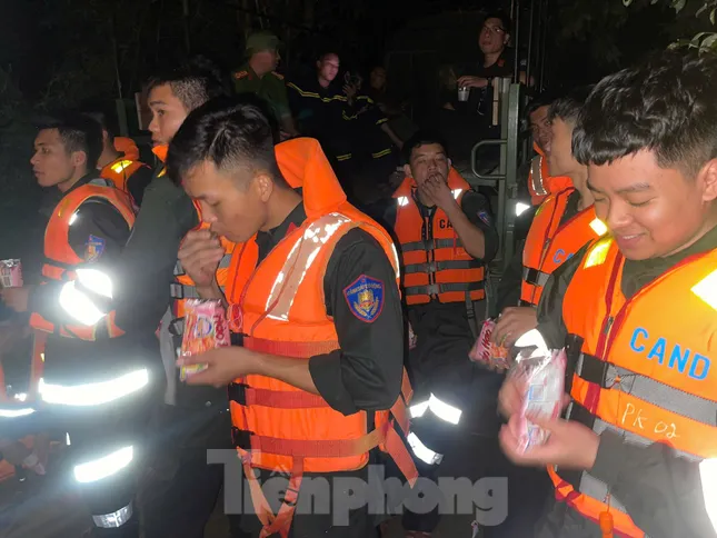 Các chiến sỹ Công an Lạng Sơn tranh thủ lót dạ rồi tiếp tục thực hiện công việc xuyên đêm cứu dân khỏi rốn lũ. Ảnh: C.H