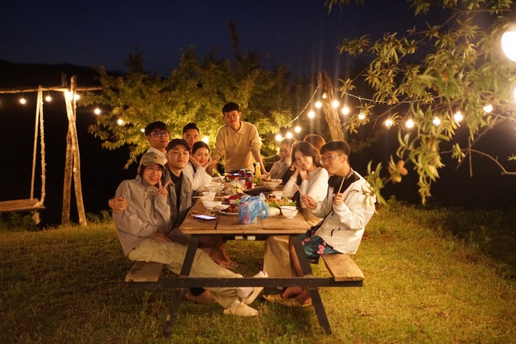 Anh Tuyên (đứng giữa) cùng nhóm du khách ăn tối tại homestay