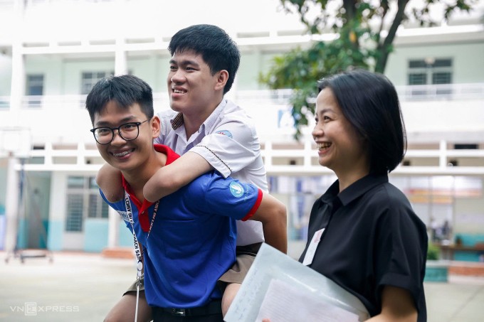 Tình nguyện viên và giáo viên đưa Lâm vào phòng làm thủ tục thi tốt nghiệp THPT, chiều 25/6. Ảnh: Quỳnh Trần