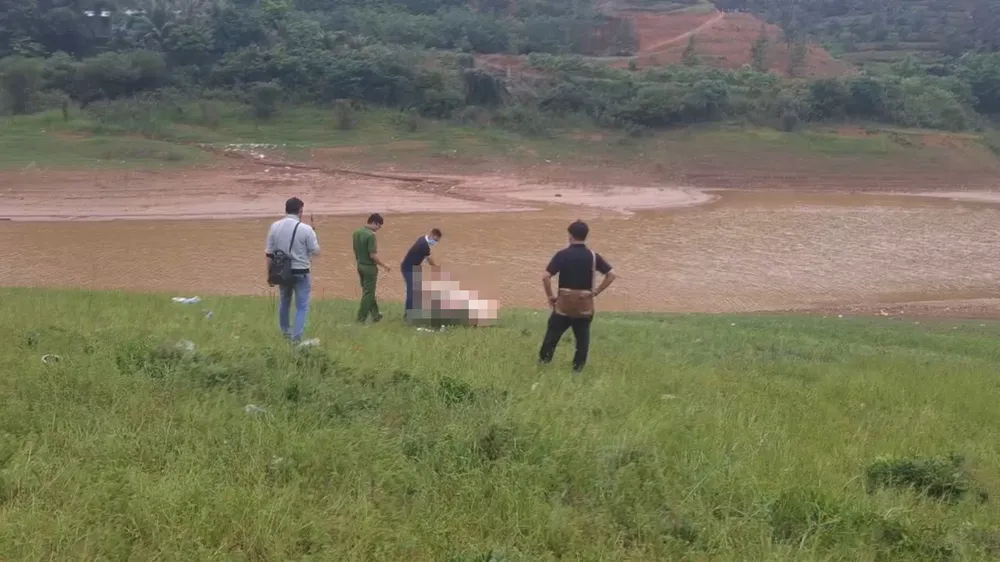 Lực lượng công an khám nghiệm thi thể người đàn ông được phát hiện dưới sông, hai tay bị trói bằng dây vải.