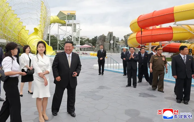 Những bức ảnh do hãng thông tấn Trung ương Triều Tiên (KCNA) công bố cho thấy, bà Ri đứng cạnh ông Kim và con gái Ju-ae trong buổi lễ ngày 24/6. Bà Ri mặc áo sơ mi trắng, quần dài đen. Còn con gái ông Kim mặc bộ váy màu trắng thanh lịch. (Ảnh: KCNA)