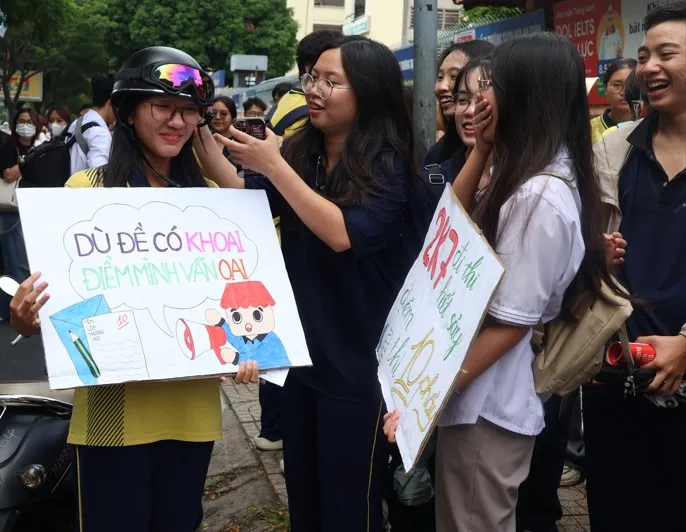 Tình nguyện viên luôn đồng hành cùng các sĩ tử trong các ngày thi với những lời động viên dễ thương. Ảnh: LONG VŨ