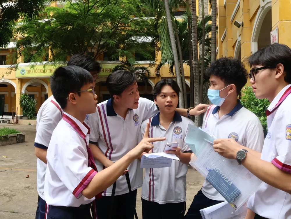 Thí sinh trao đổi bài sau khi kết thúc buổi thi sáng nay. Ảnh: LONG VŨ