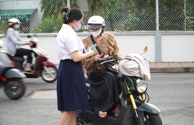 Một thí sinh được phụ huynh đưa đến điểm thi THPT Phú Nhuận, TP HCM, ngày 26/6. Ảnh: Thanh Phúc