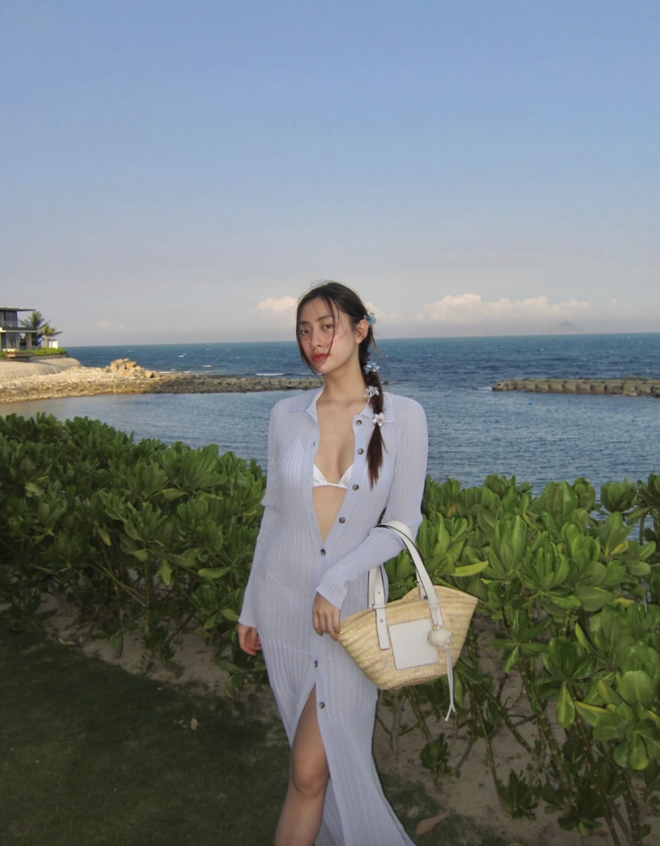 Hoa hậu chọn mẫu đầm dệt kim mỏng manh, mở phanh cúc khi diện bikini 'tí hon' để tạo vẻ nửa kín nửa hở.