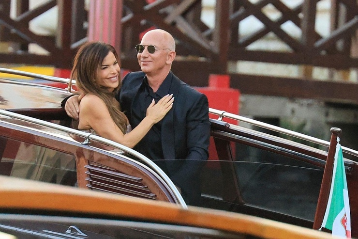 Vợ chồng tỷ phú Jeff Bezos thể hiện tình cảm trên taxi nước. Cô dâu mới diện váy từ nhà mốt Atelier Versace, chú rể mặc vest và kính râm cùng tông màu. Ảnh: Splash News