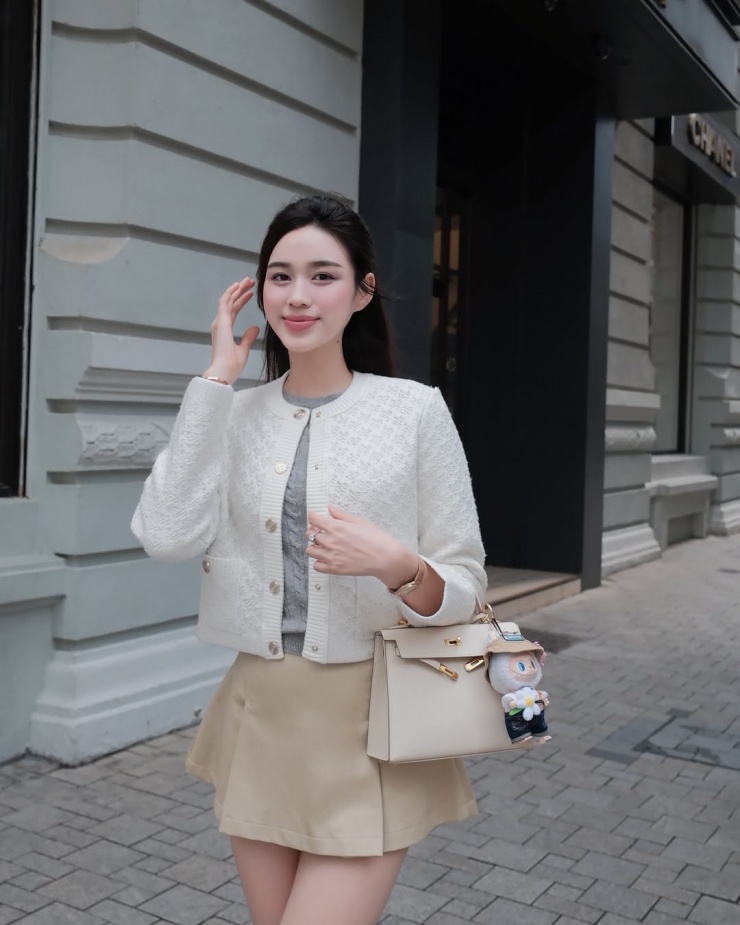 Hoa hậu Đỗ Thị Hà dạo phố với cardigan, áo len và chân váy ngắn màu sắc trung tính theo đúng tinh thần "Tiền cũ". Ngoài những tông màu này, Old Money còn được thể hiện với sắc đậm và trầm gồm đỏ, xanh lá hoặc xanh cobalt, tím.