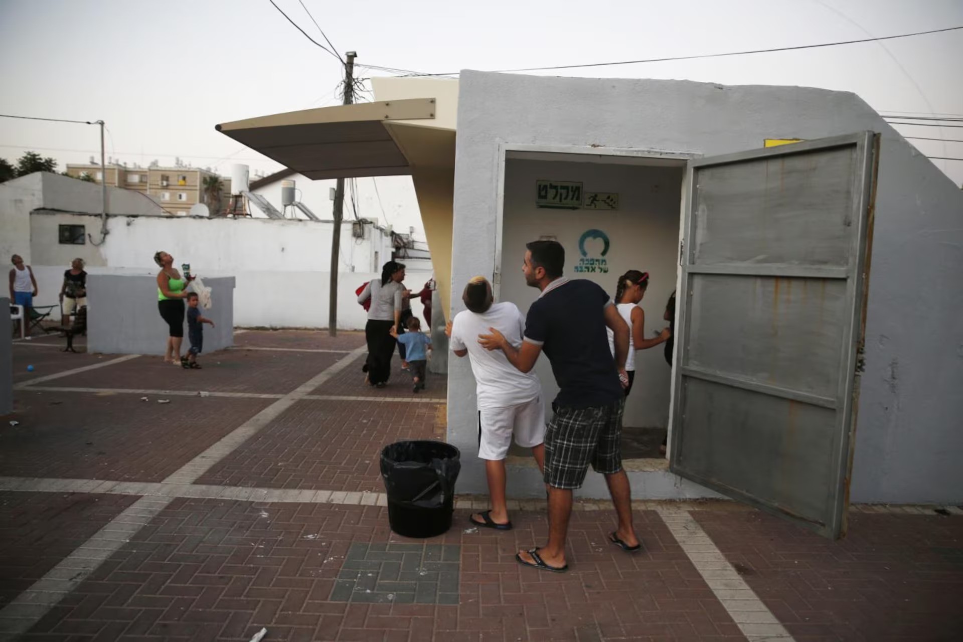 Người dân Israel tìm chỗ ẩn nấp khi nghe thấy còi báo động không kích (ảnh: Reuters)