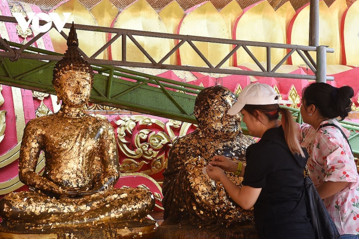Người dân đến lễ chùa Wat Tham Suea&nbsp;thường mua vàng quỳ dán lên các bức tượng Phật trong chùa.