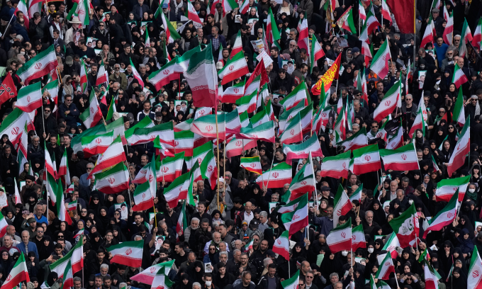 Người dân Iran vẫy quốc kỳ khi tham dự lễ tang của tư lệnh hải quân IRGC ở Tehran hôm 1/4. Ảnh: AP