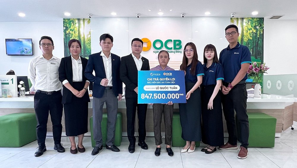 Đại diện OPES và OCB chi trả quyền lợi bảo hiểm cho gia đình anh Tuấn.