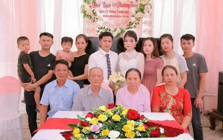 Vợ chồng chị Oanh (ngoài cùng bên trái) cùng gia đình chụp ảnh kỷ niệm trong đám cưới của cặp đôi Thúy - Biên vào năm 2021