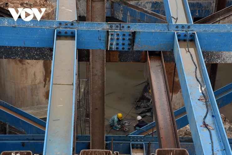 Theo đại diện chủ đầu tư, ở phía bờ Long Biên mặt bằng cơ bản thuận lợi hơn, cho phép nhà thầu triển khai thi công liên tục. Tuy nhiên, khu vực này lại phát sinh vướng mắc liên quan đến việc kết nối với trục đại lộ cảnh quan sông Hồng. Do chưa có quyết định chính thức về hướng tuyến, một số vị trí trụ cầu dẫn phải tạm dừng để chờ phương án, khiến tiến độ bị ảnh hưởng và nguồn lực thi công chưa thể phát huy tối đa.