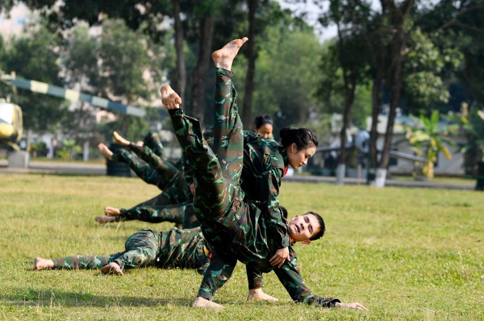 Thùy Dung học võ cổ truyền Bình Định nhiều năm, thành thục các động tác võ thuật khi tập đánh đối kháng với đồng đội nam. Ảnh: Huy Nguyễn