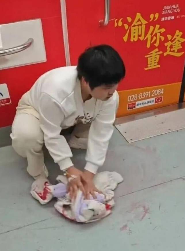 Hu dùng áo lau sạch vết máu trên tàu điện ngầm hôm 23/3. Ảnh: China News